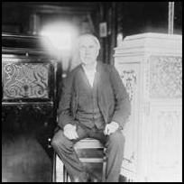 Thomas Alva Edison sits between two phonograph cabinets