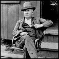 Thomas Alva Edison sitting at the door of the ore-milling plant in New Jersey